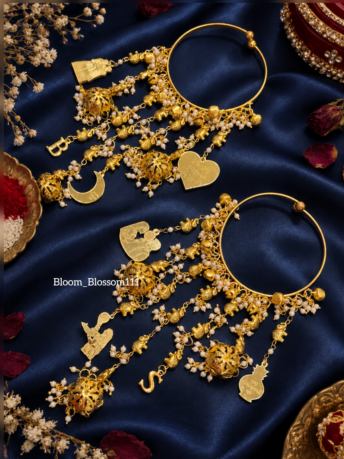 Pair of gold-tone Mini Gajraj bangles with dangling charms on dark blue fabric